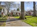 Well-maintained brick home with lush landscaping and a charming facade nestled among mature trees at 2309 Shenandoah Ave, Charlotte, NC 28205