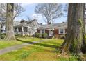 A well-kept brick home with a cozy front yard, complemented by mature trees and nearby houses at 2309 Shenandoah Ave, Charlotte, NC 28205