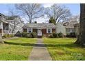 Inviting single-story brick home featuring a well-manicured lawn and tidy landscaping in a desirable neighborhood at 2309 Shenandoah Ave, Charlotte, NC 28205