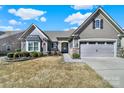 Charming home featuring stone accents, a manicured front yard, and an attached two car garage at 3097 Arches Bluff Cir, Lancaster, SC 29720