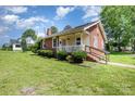 A charming, brick-clad house with a cozy front porch and well-maintained lawn, perfect for enjoying outdoor living at 404 E 1St St, Cherryville, NC 28021
