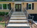 Inviting home entrance featuring a tiled staircase, metal handrails, and a stylish double-door entryway at 4216 Maureen Dr, Charlotte, NC 28205