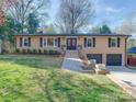 Inviting single-Gathering home with lush lawn, brick facade, black shutters and a two-car garage at 4216 Maureen Dr, Charlotte, NC 28205