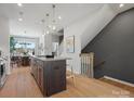 Kitchen featuring a large island, pendant lighting, and stainless steel appliances, adjacent to a staircase at 5719 Castlerea Dr, Charlotte, NC 28217