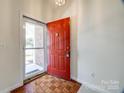 Inviting entryway featuring a red front door and parquet flooring at 7124 Bevington Woods Ln, Charlotte, NC 28277