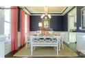 Elegant dining room with coffered ceiling, wainscoting, stylish chandelier, and a view into the kitchen at 7645 Bainbridge Rd, Sherrills Ford, NC 28673