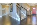 Elegant foyer featuring hardwood floors, staircase with metal spindles, and a bright red front door at 7645 Bainbridge Rd, Sherrills Ford, NC 28673