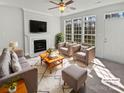 Bright living room with fireplace, large windows, and cozy seating arrangement at 9832 Veronica Dr, Charlotte, NC 28215