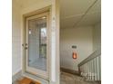 A front door with glass pane and a white trim and stairs nearby at 1001 Churchill Downs Ct # A, Charlotte, NC 28211