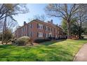 Three story brick building with manicured lawn and mature trees surrounding the property at 103 S Laurel Ave, Charlotte, NC 28207