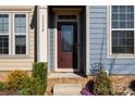 Close-up of a charming front door with decorative glass, stone accents, and manicured landscaping at 11332 Westbranch Pkwy, Davidson, NC 28036