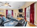 Cozy living room showcasing a stone fireplace, vaulted ceilings, hardwood floors, and comfortable seating at 1263 Waterford Dr, Hickory, NC 28602