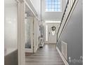 Bright, two story foyer features gray walls, hardwood floors, and a beautiful front door with large windows at 12836 Harvest Time Ct, Charlotte, NC 28278