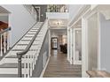 Staircase featuring gray walls, hardwood floors, and views to the front door at 12836 Harvest Time Ct, Charlotte, NC 28278