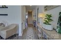 Bright hallway with hardwood floors, elegant trim, and stylish decor leading to the staircase at 14230 Morningate St, Huntersville, NC 28078