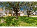Beautiful home nestled among mature trees, showcasing a lush green lawn and inviting curb appeal at 1812 Rosewell Dr, Rock Hill, SC 29732