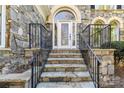 Stone facade, stone steps, and black iron railings lead to the front door of this beautiful home at 18512 Square Sail Rd, Cornelius, NC 28031