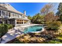 Backyard featuring a private pool, a spacious deck, and lush landscaping, creating a serene outdoor oasis at 18512 Square Sail Rd, Cornelius, NC 28031