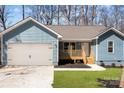 Charming blue home showcasing a two-car garage and a inviting wooden porch at 186 Byers Rd, Troutman, NC 28166