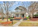 Inviting two-story home showcasing a well-manicured lawn, covered porch, and classic architectural style at 18710 Coverdale Ct, Cornelius, NC 28031