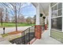 View of front porch with brick accents and hanging flower baskets at 18710 Coverdale Ct, Cornelius, NC 28031