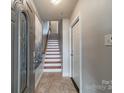 Inviting entryway with a staircase featuring wood and white accents and tile flooring at 2953 Craftsman Ln, Charlotte, NC 28204