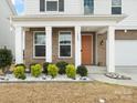 Charming front porch with brick accents, white columns, and a vibrant front door enhancing the curb appeal at 3008 Quinebaug Rd, Fort Mill, SC 29715