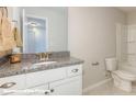 Bathroom featuring granite countertop, white cabinets, sink, faucet and toilet with shower-tub combo at 113 Asmodean Ln, Troutman, NC 28166