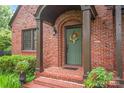 Inviting front door with brick archway and lush landscaping creating a warm welcome at 600 S Central Ave, Belmont, NC 28012
