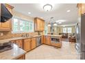 Open kitchen with granite countertops, stainless appliances, and seamless flow to living area at 600 S Central Ave, Belmont, NC 28012