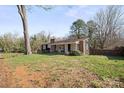 Classic home with a brick chimney, covered porch, and mature trees in a serene setting at 709 S Cedar St, Lincolnton, NC 28092