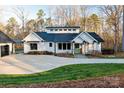 Beautiful modern farmhouse with black trim, a green front door, and a well-manicured lawn at 7403 Grassy Ridge Rd, Denver, NC 28037