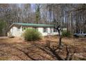 Ranch style home, metal roof, mature trees on a large lot, with a pick-up truck in the driveway at 7597 Webbs Rd, Denver, NC 28037