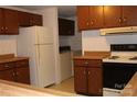 Functional kitchen featuring wood cabinets, a white refrigerator, and essential appliances at 7597 Webbs Rd, Denver, NC 28037
