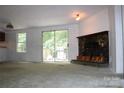 Spacious living room with a stone fireplace and sliding glass doors, creating a warm and inviting atmosphere at 7597 Webbs Rd, Denver, NC 28037