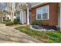 Charming townhome entrance with brick facade, lush landscaping, and decorative stone accents at 8364 Chaceview Ct, Charlotte, NC 28269