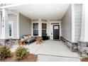 Inviting front porch showcasing stylish seating, plants, stone accents, and a welcoming entrance at 1018 Heritage Pointe # 302, Indian Trail, NC 28079