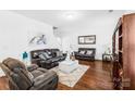 Inviting living room with plush seating, a decorative mirror, and warm wood floors at 11320 Joe Morrison Ln, Charlotte, NC 28214