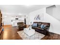 Open-concept living area featuring hardwood floors and modern decor and a view to kitchen at 11320 Joe Morrison Ln, Charlotte, NC 28214