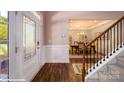Elegant entryway with hardwood floors, wainscoting, decorative door, and staircase to the upper level at 121 Asmodean Ln, Troutman, NC 28166