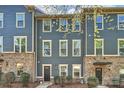 Charming townhome featuring a blue exterior, brick accents, and well-maintained landscaping at 1317 Queen Lyon Ct, Charlotte, NC 28205