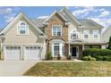 Charming two-story home featuring a two-car garage, brick accents, and a well-maintained lawn at 1615 Jekyll Ln, Waxhaw, NC 28173