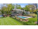 Resort style backyard includes a stone patio, pristine pool, and well-manicured lawn with a view at 19528 Mary Ardrey Cir, Cornelius, NC 28031