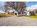 View of house and detached garage with a gravel driveway and mature trees at 1993 Moss Farm Rd, Hickory, NC 28602