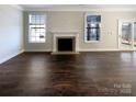 Spacious room offers hardwood floors, neutral walls, a fireplace and windows with natural light at 2085 Saddlebred Dr, Iron Station, NC 28080