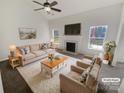 Bright living room with fireplace, neutral colors, a ceiling fan and large windows at 2115 Genesis Dr, Monroe, NC 28110