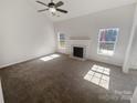 Spacious living room featuring neutral colors, a ceiling fan, fireplace and large windows at 2115 Genesis Dr, Monroe, NC 28110