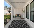 Inviting covered front porch featuring a bench, stylish rug, and black trimmed windows at 218 Alenda Lux Cir, Mooresville, NC 28115