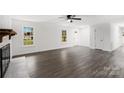 Bright living room featuring light gray flooring, a white-painted brick fireplace, and two large windows at 2225 Grace Church Rd, Salisbury, NC 28147