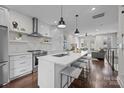 Open-concept kitchen with island seating, stainless steel appliances, and modern white cabinetry, open to the living room at 3655 Vallette Ct, Charlotte, NC 28203